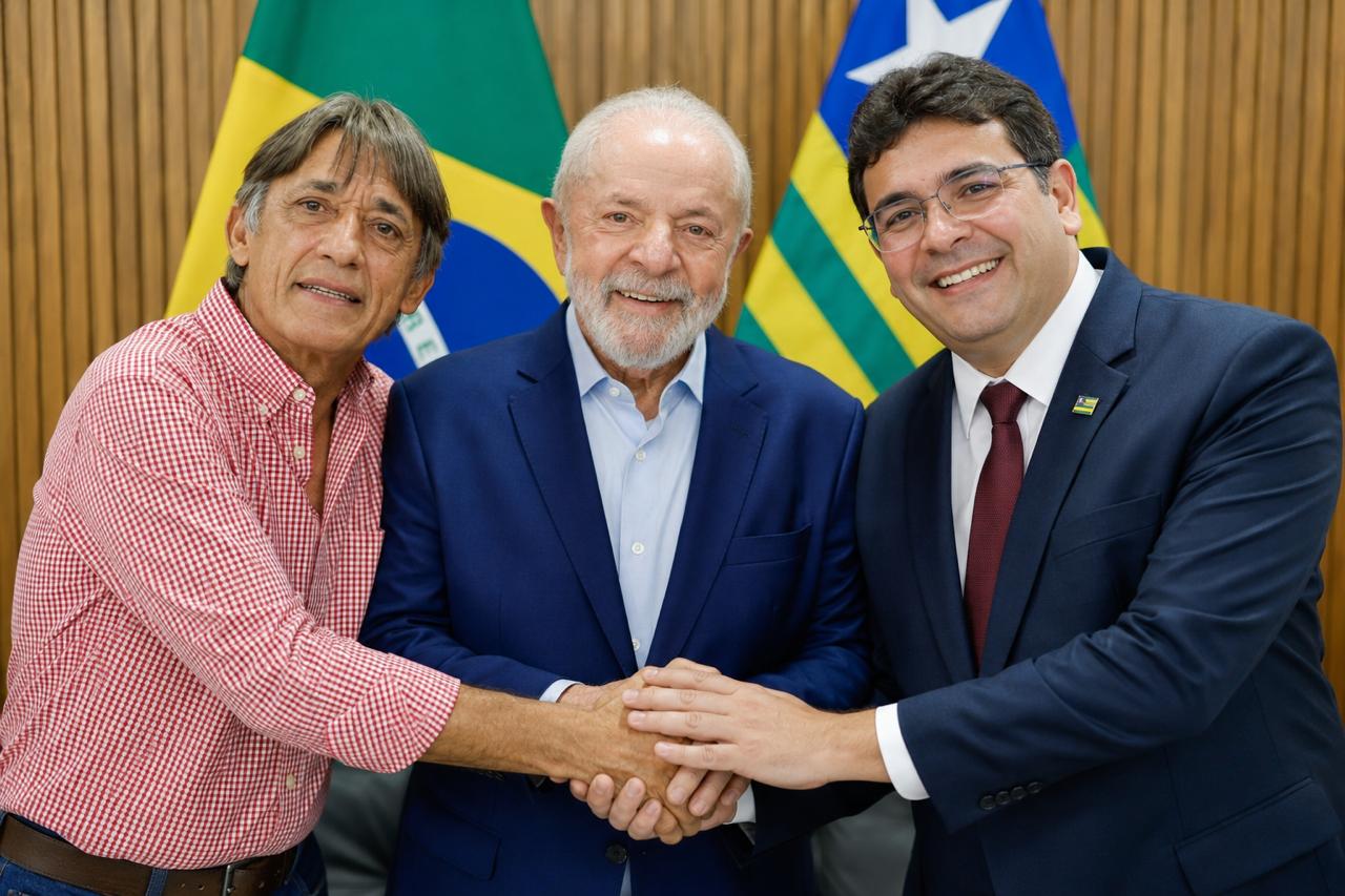 Joaquim Saraiva ao lado do Presidente Lula e de outro político, com as mãos unidas